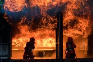 Firefighter Concept. Fireman using water and extinguisher to fighting with fire flame. firefighters