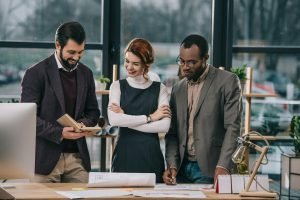 multiethnic architects discussing work in modern office