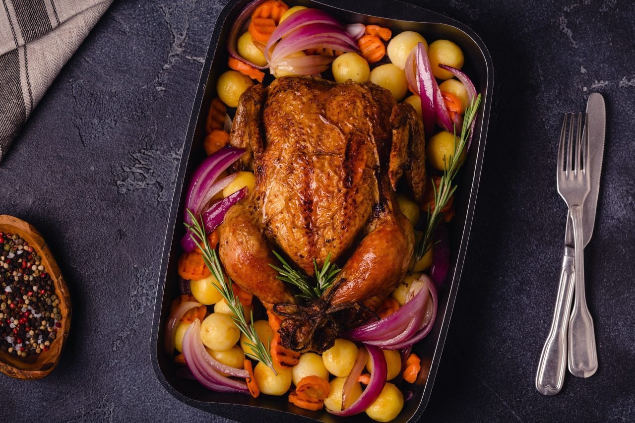 Whole baked chicken with vegetables.