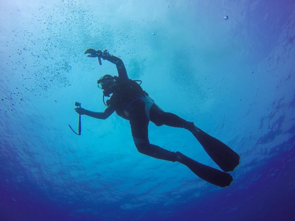 Underwater scuba diving selfie shot with selfie stick. Deep blue sea. Wide angle shot.
