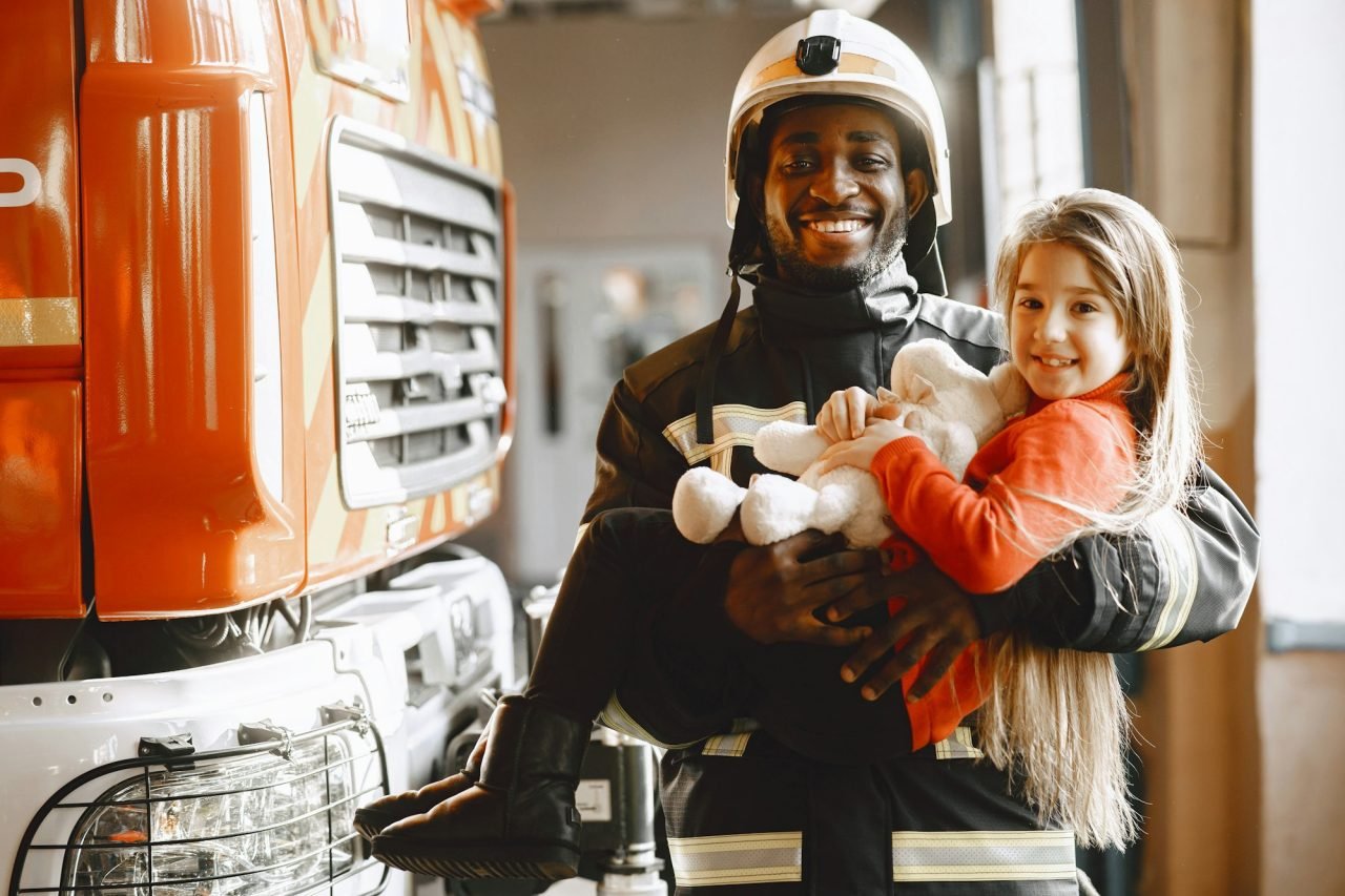 Portrait of a firefighter standing in front of a fire engine