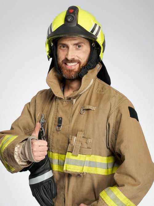 Professional firefighter showing thumb up to camera in studio.