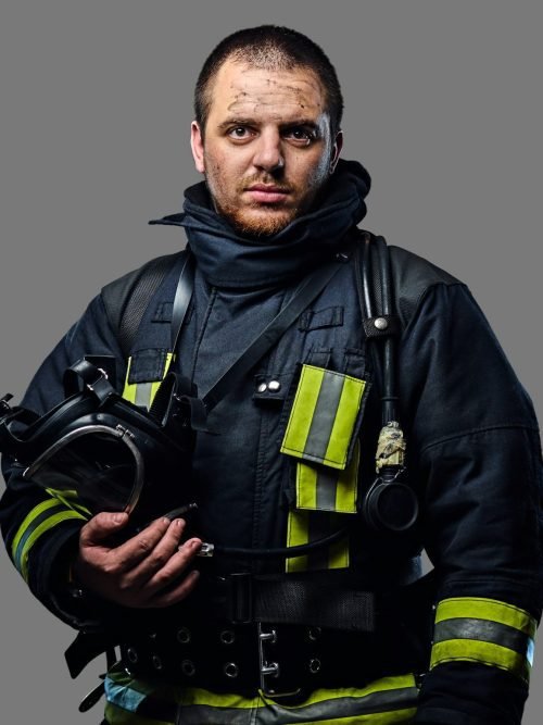 Studio portrait of a male dressed in a firefighter uniform.