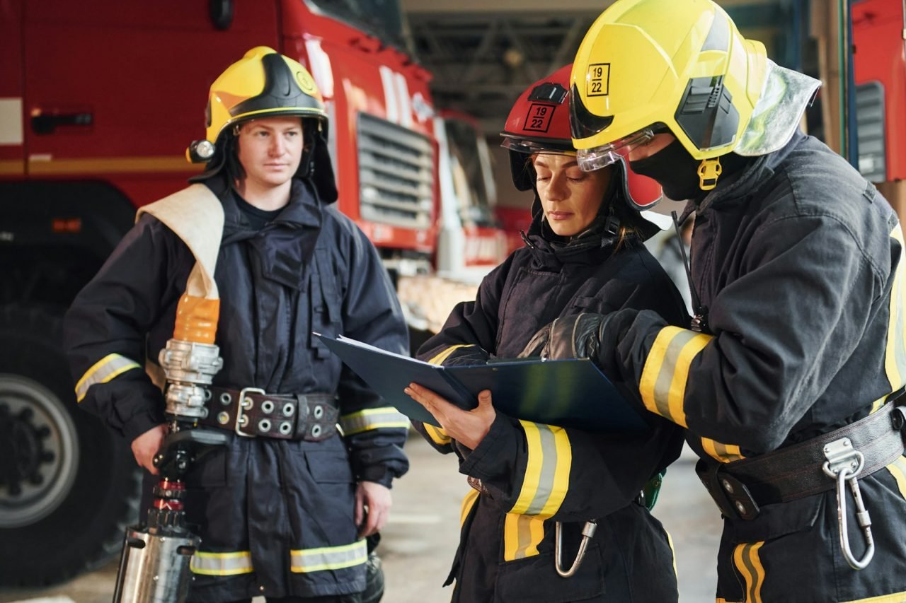 With notepad. Group of firefighters in protective uniform that is on station