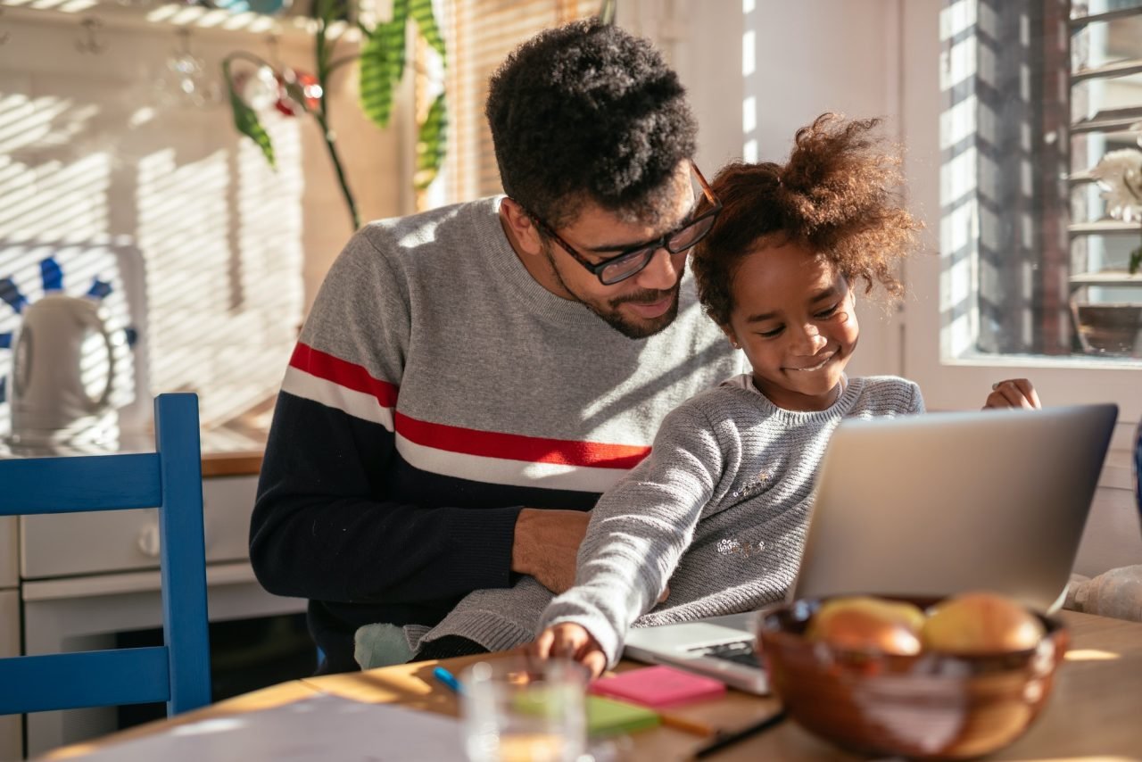 Father and daughter using laptop and smiling!
