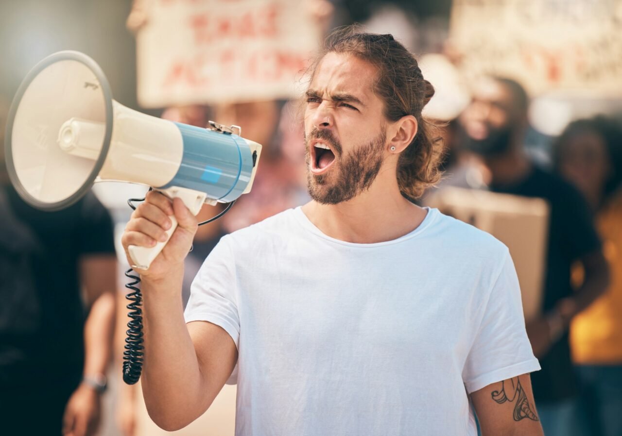 Megaphone, protest and man leader speaking at rally for politics, equality and human rights. Revolu