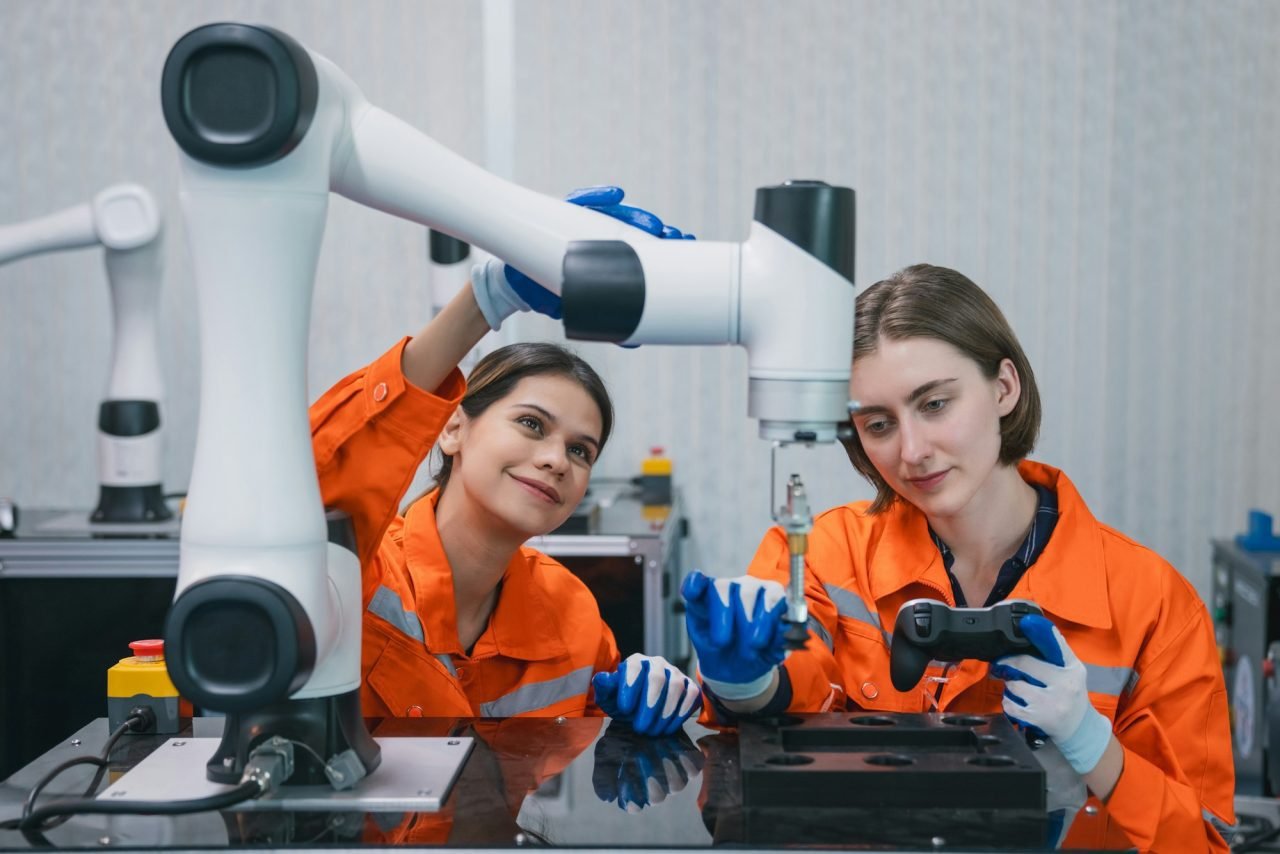 Student engineer Assembling Robotic Arm with computer in Technology Workshop.