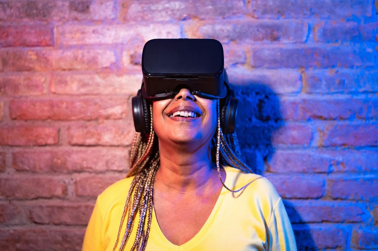 Senior African woman having fun playing with innovated virtual reality glasses
