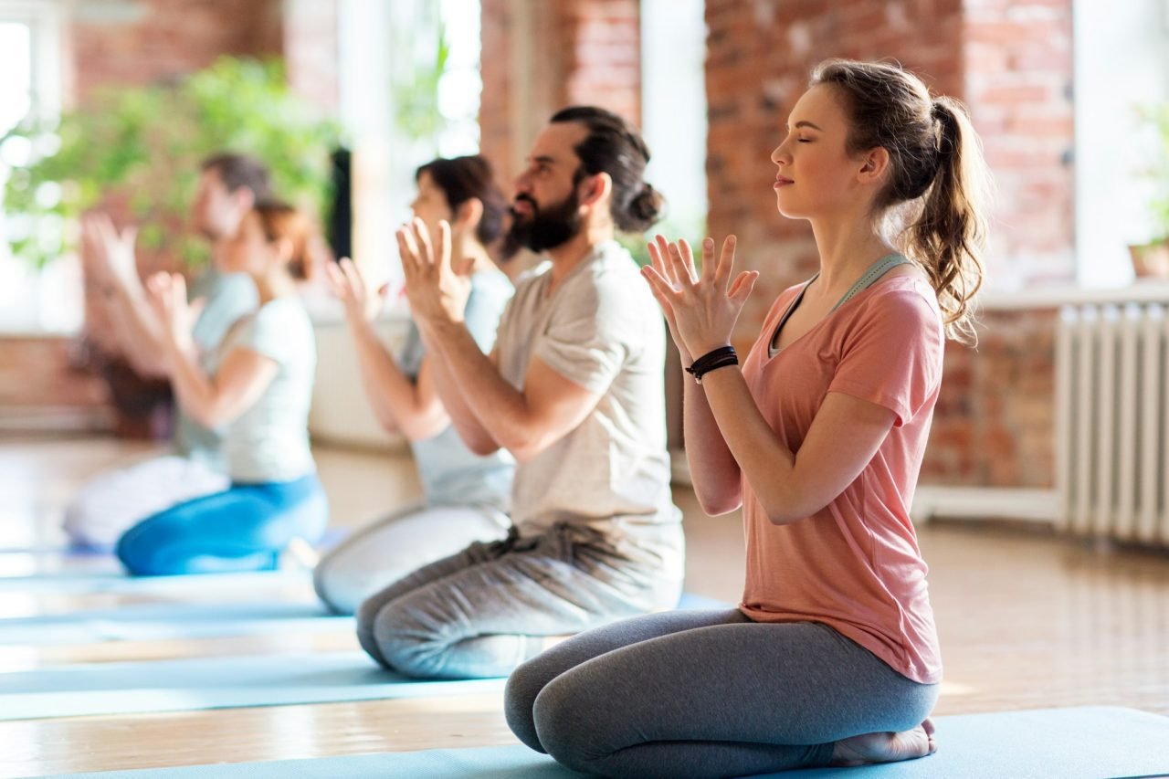 group of people meditating at yoga studio